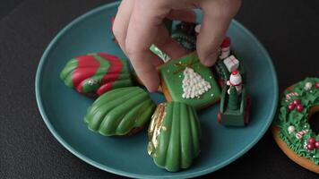 Sweet Madeleines desserts covered with chocolate in Christmas colors, with various toppings on a dark concrete background video