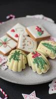 Sweet Madeleines desserts covered with chocolate in Christmas colors, with various toppings on a dark concrete background video