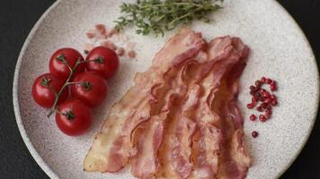 Bacon sliced, grilled with salt and spices on a dark concrete background video