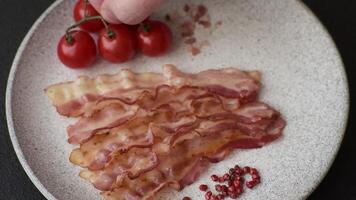 Bacon sliced, grilled with salt and spices on a dark concrete background video