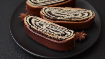 Sweet homemade roll with poppy seeds on a dark concrete background video