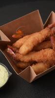 Hot crispy shrimp breaded with salt and spices with white sauce on a dark concrete background video