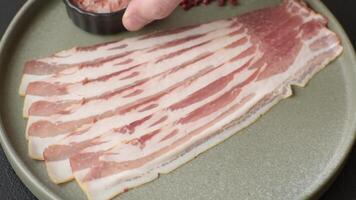 Fresh raw bacon sliced with spices and herbs on a dark concrete background video