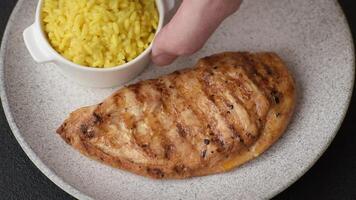 Grilled chicken fillet with salt, spices and herbs on a dark concrete background video