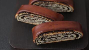 Sweet homemade roll with poppy seeds on a dark concrete background video
