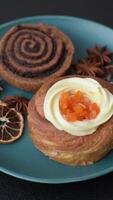 Sweet dessert danish covered with white cream and citrus, with cream filling on a dark concrete background video