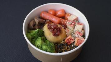 Boiled beef with vegetables, grains, seeds and spices in a ceramic plate on a dark concrete background video