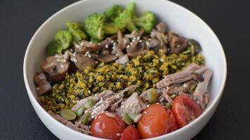 Quinoa bowl with tofu, steamed vegetables, grains, seeds and spices on a dark concrete background video