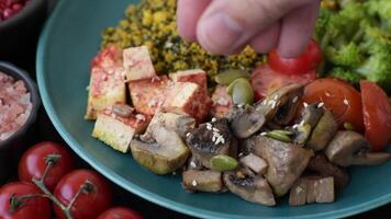 Boiled beef with vegetables, grains, seeds and spices in a ceramic plate on a dark concrete background video