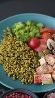 Quinoa bowl with tofu, steamed vegetables, grains, seeds and spices on a dark concrete background video