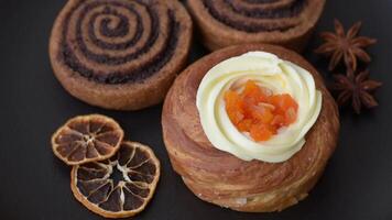 Sweet dessert danish covered with white cream and citrus, with cream filling on a dark concrete background video