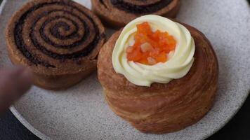 Sweet dessert danish covered with white cream and citrus, with cream filling on a dark concrete background video