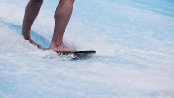 Close-up legs surfer balancing on surfboard. Water sports activity. Instructor demonstrating how to stand up on surfboard. The concept of practice and perseverance before it succeeds. Free copy space video