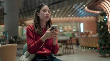 Woman in Red.A young woman with a warm smile, engrossed in conversation on her smartphone, captures the essence of modern communication and connection. video