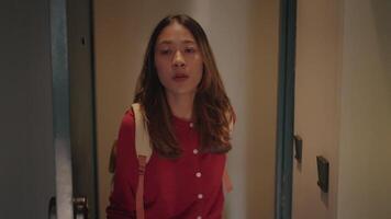 A young woman walks down a dimly lit corridor. Her expression shows concern or contemplation. The atmosphere is mysterious and slightly unsettling. video