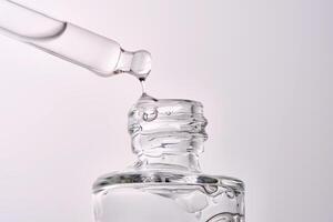 Close-up of a cosmetic bottle with a pipette showing the texture of the serum. photo