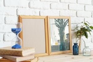 Photo frames on a brick wall background on the table with wheat ears in vase