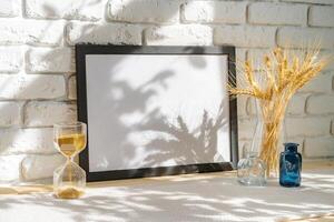 Photo frames on a brick wall background on the table with wheat ears in vase