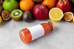 Various fruits and freshly squeezed fruits juice in bottle on gray background photo