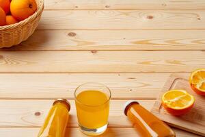 Glass of fresh orange juice with fresh fruits on wooden table photo