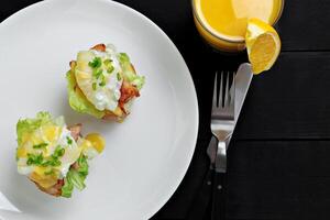 Top view of toasted buns with bacon, lettuce and poached egg photo