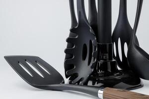 Stand with set of kitchen utensils on white background photo