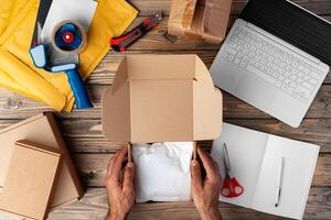 Packing products for delivery on wooden table, top view photo