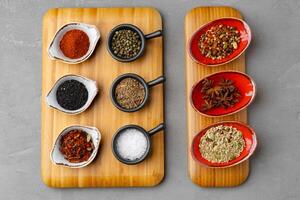 Small bowls with spices on gray background photo