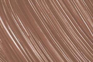 Swirling patterns of brown and white create an artistic texture on a smooth, soft surface during daylight photo