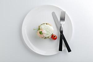 Russian salad Olivier served with poached egg on top photo