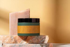 Cosmetic product jar in composition with granite stones and shadow photo