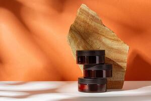 Cosmetic product jar in composition with granite stones and shadow photo