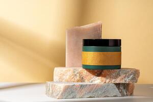 Cosmetic product jar in composition with granite stones and shadow photo