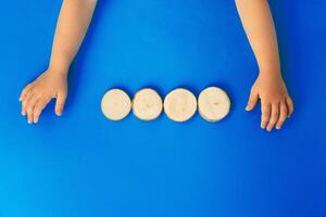 Hands of a kid with four wooden blocks, top view photo
