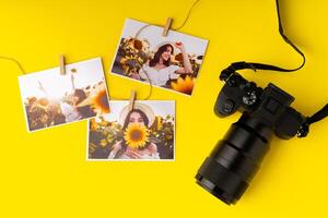 Photo camera with colorful printer photos on yellow background