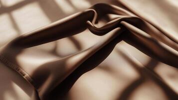 Soft brown fabric draped elegantly with light and shadow patterns in a warm indoor setting photo