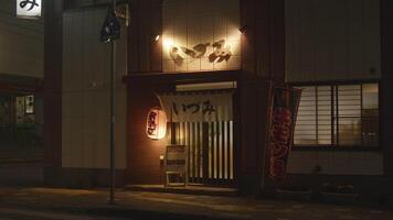 A traditional Japanese izakaya adorned with lanterns, inviting patrons into a world of authentic flavors. video