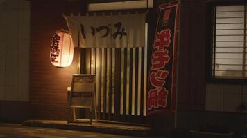 A traditional Japanese izakaya adorned with lanterns, inviting patrons into a world of authentic flavors. video