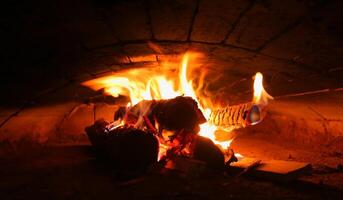 Several burning logs in a brick oven photo