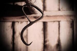 Rusty hook in a grained image and spooky setting photo