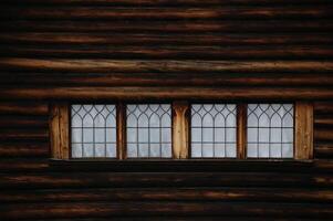 Wall of a log hut with windows photo