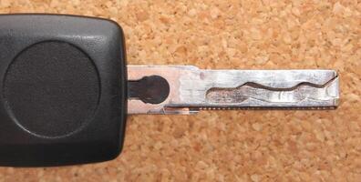 Side view of a car key in front of pin board photo