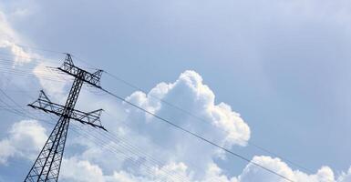 Unusual tilted composition of power lines and cloudscape on blue sky photo