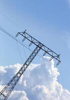 Unusual tilted composition of power lines and cloudscape on blue sky photo