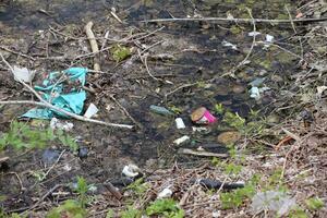 Rotting pond filled with waste and packaging photo
