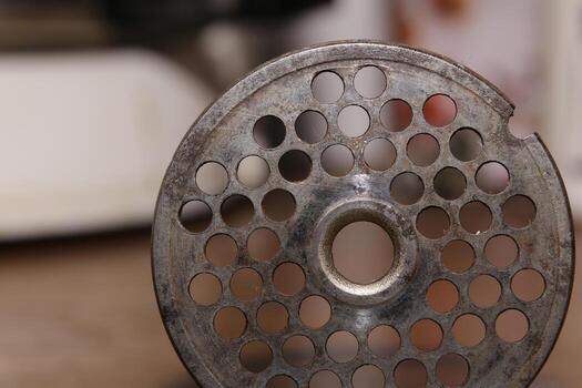 Perforated disk used as part of an old meat grinder photo