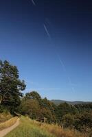 Beautiful landscape in Baden-Wurttemberg with diagonal vapor trail on blue sky photo