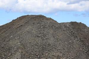 Heap of gravel in front of sky photo