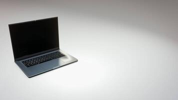A laptop computer is shown on a white surface video