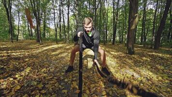 Man with battle ropes. Strong man exercising with battle ropes in park video